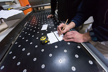 Image showing carpenters calculating and programming a cnc wood working machin