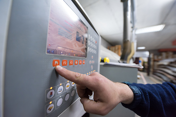 Image showing carpenter calculating and programming a cnc wood working machine