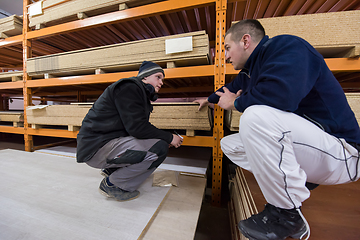 Image showing two young carpenters writing new prices