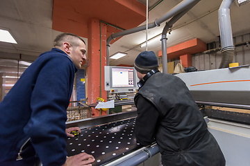 Image showing carpenters calculating and programming a cnc wood working machin