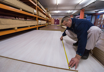 Image showing carpenter measuring wooden board