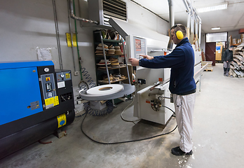 Image showing carpenter calculating and programming a cnc wood working machine