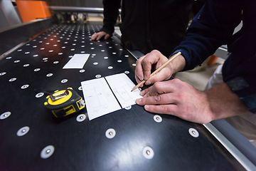 Image showing carpenters calculating and programming a cnc wood working machin