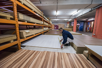 Image showing carpenter measuring wooden board