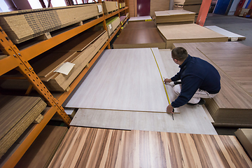 Image showing carpenter measuring wooden board