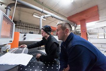 Image showing carpenters calculating and programming a cnc wood working machin