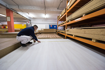 Image showing carpenter measuring wooden board