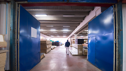 Image showing carpenter walking through factory