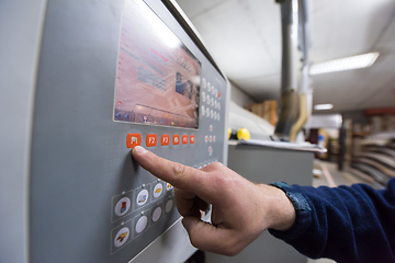 Image showing carpenter calculating and programming a cnc wood working machine