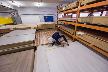 Image showing carpenter measuring wooden board