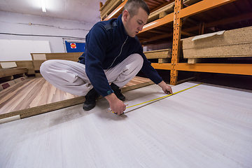 Image showing carpenter measuring wooden board