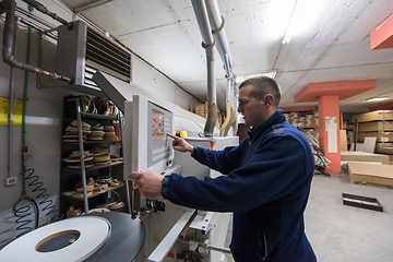 Image showing carpenter calculating and programming a cnc wood working machine