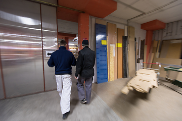 Image showing two young carpenters working in big modern carpentry