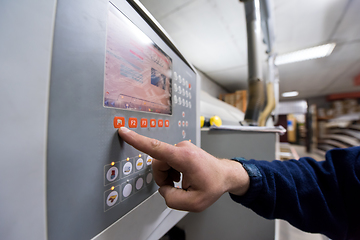 Image showing carpenter calculating and programming a cnc wood working machine