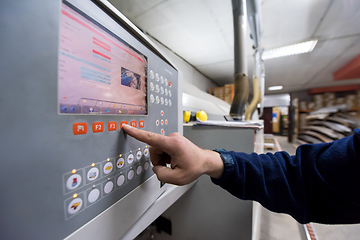 Image showing carpenter calculating and programming a cnc wood working machine