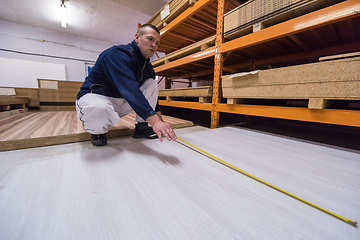 Image showing carpenter measuring wooden board