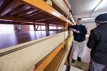 Image showing two young carpenters working in big modern carpentry