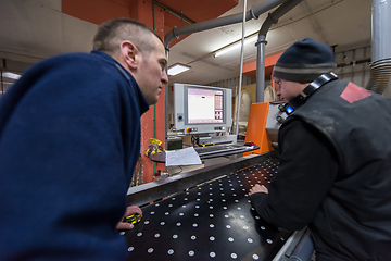 Image showing carpenters calculating and programming a cnc wood working machin