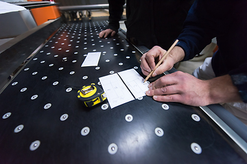 Image showing carpenters calculating and programming a cnc wood working machin