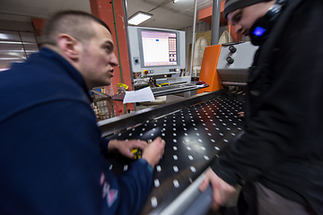 Image showing carpenters calculating and programming a cnc wood working machin