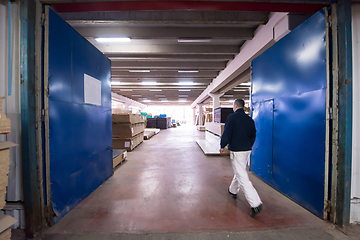 Image showing carpenter walking through factory