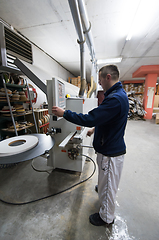 Image showing carpenter calculating and programming a cnc wood working machine