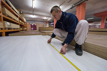 Image showing carpenter measuring wooden board