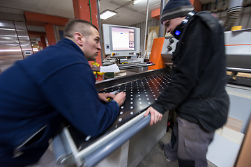 Image showing carpenters calculating and programming a cnc wood working machin