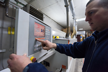 Image showing carpenter calculating and programming a cnc wood working machine