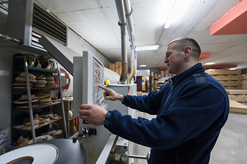 Image showing carpenter calculating and programming a cnc wood working machine