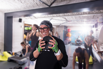 Image showing sporty woman holding a metal round weights plate