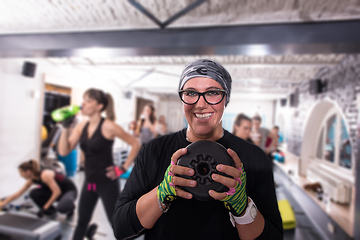 Image showing sporty woman holding a metal round weights plate