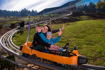 Image showing young mother and son driving alpine coaster