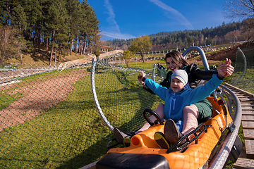 Image showing young mother and son driving alpine coaster