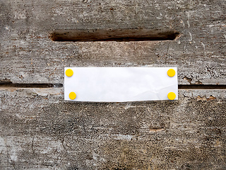 Image showing mailbox slot on a wooden door with white paper