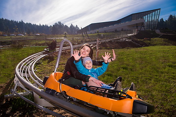 Image showing young mother and son driving alpine coaster