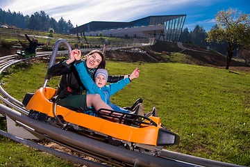 Image showing young mother and son driving alpine coaster