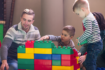 Image showing young parents and kids having fun at childrens playroom