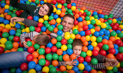 Image showing parents and kids playing in the pool with colorful balls