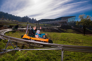 Image showing young mother and son driving alpine coaster