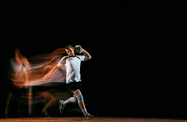 Image showing Young handball player against dark studio background in mixed light