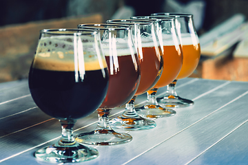 Image showing Glasses of different kinds of beer on wooden background