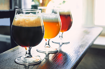 Image showing Glasses of different kinds of beer on wooden background