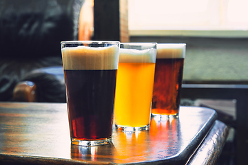 Image showing Glasses of different kinds of beer on wooden background