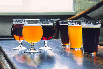 Image showing Glasses of different kinds of beer on wooden background