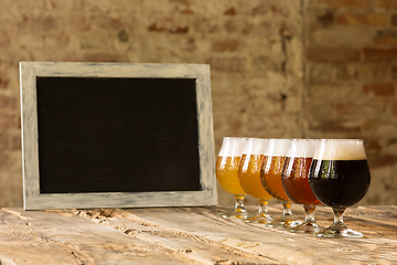 Image showing Glasses of different kinds of beer on wooden background