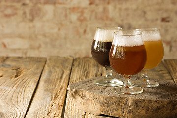 Image showing Glasses of different kinds of beer on wooden background