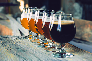 Image showing Glasses of different kinds of beer on wooden background