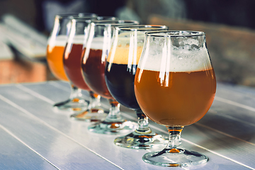 Image showing Glasses of different kinds of beer on wooden background