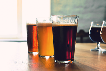 Image showing Glasses of different kinds of beer on wooden background